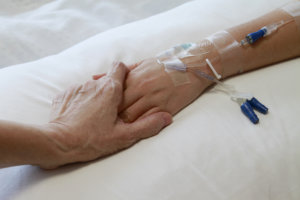 caregiver holding patient's hand
